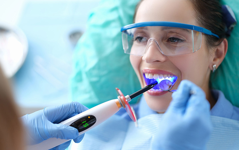 Woman having teeth inspected with a UV light