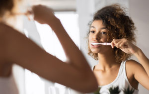 Woman brushing teeth with fluoride toothpaste