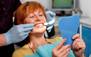 Woman looking at teeth in mirror
